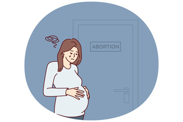 Upset pregnant woman stands near door with abortion sign needs psychologist after making difficult decision. Girl crying wants to terminate pregnancy due to unwanted insemination - 785541054