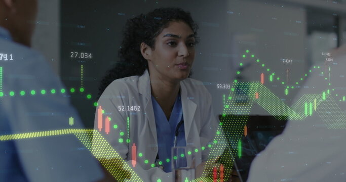 Image of multiple graphs and numbers over diverse female doctor discussing with colleagues - Powered by Adobe