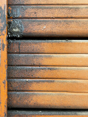 A shutter with a portion having grease, and the surrounding area is covered in rust