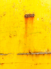 A yellow wall with a rusty spot on it