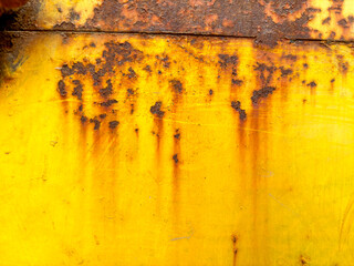 A yellow wall with a rusty spot on it