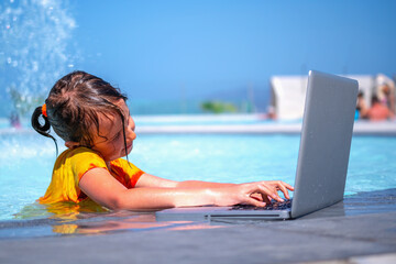 Learning and study everywhere and always. Portrait of young girl learning with laptop computer in the swimming pool.