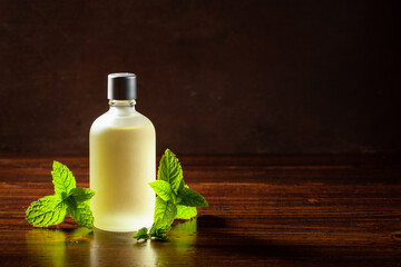 Fresh mint leaves, essential oil on wooden table