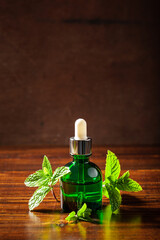 Fresh mint leaves, essential oil on wooden table