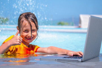 Distance Learning, learning and study everywhere and always. Portrait of young happy girl learning with laptop computer in the swimming pool.