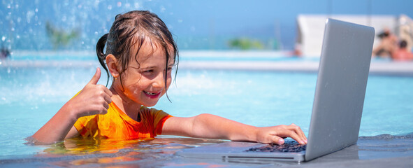Distance Learningю Learning and study everywhere and always. Portrait of young girl learning with laptop computer in the swimming pool water. Horizontal image.