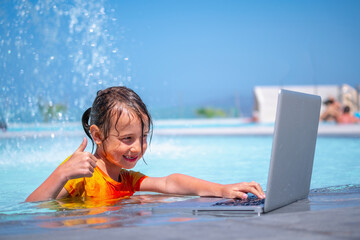 Distance Learningю Learning and study everywhere and always. Portrait of young girl learning with laptop computer in the swimming pool water. - 785546058