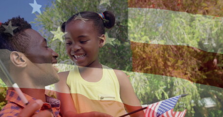 Image of usa flag over happy african american father and daughter with ua flags