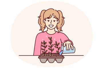 Little girl is watering plant in form of eggshell for concept of ecology and zero waste gardening. Caring teenage schoolgirl is gardening growing kitchen herbs and spices for cooking - 785548285