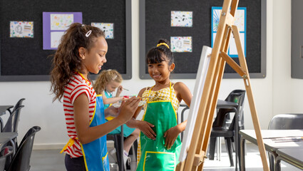 Obraz premium In school, in art class, a diverse group of young girls are painting