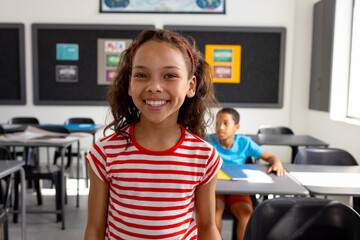 In school, in the classroom, a biracial girl and boy are focusing on learning - Powered by Adobe