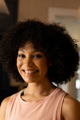 Biracial young woman smiling, wearing casual clothes at home