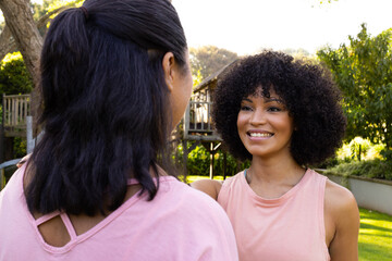 Biracial mother and daughter are talking outside at home
