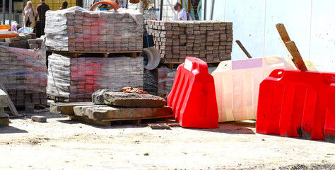 Materials for the repair of water pipes were collected on the square. Plastic large orange pipes, concrete circles and cobblestones and temporary blocks to restrict traffic. repair.