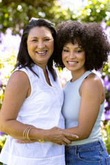 Mother and Daughter, biracial mother and daughter, embracing, standing in garden at home