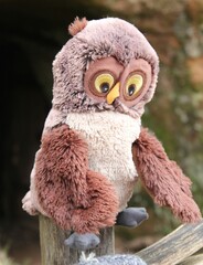 Naklejka premium a beautiful handmade symbol of wisdom fabric owl on a wooden pole