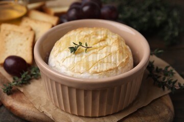 Tasty baked camembert in bowl on table, closeup