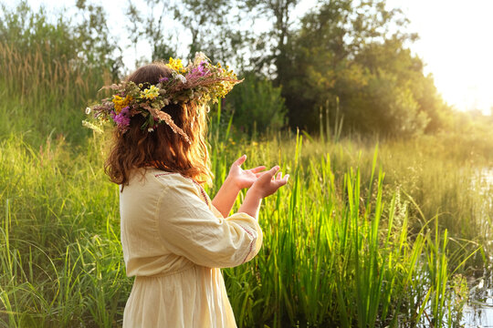 girl in flower wreath outdoor, natural sunny background. Floral crown, symbol of summer solstice. ceremony for Midsummer, wiccan Litha sabbat. spiritual esoteric ritual. pagan folk holiday Ivan Kupala