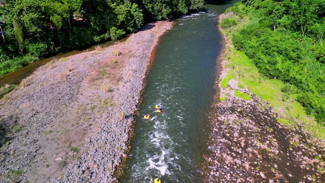 Drone flying above Sarapiqui River with people in boats having Tubing and Kayak adventure