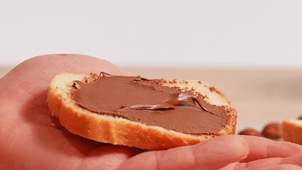 Breakfast. sandwich with nut butter. Hazelnuts on the table and chocolate spread on bread