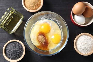 Ingredients for homemade dough on black wooden table, flat lay