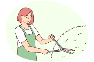 Female gardener cutting bushes
