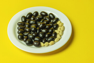 peanut dragee on a white plate covered with chocolate