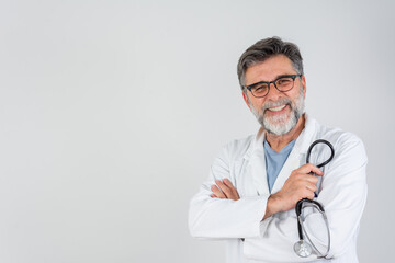 Healthcare, medical staff concept. Portrait of smiling male doctor posing with folded arms on grey studio background, free space. Professional general practitioner.