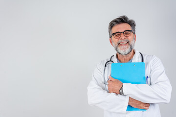 Smiling male doctor with clipboard. Portrait of confident mature medical doctor on grey background. Male Doctor standing with folder, isolated on white background