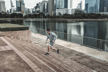 A man  running up on stairs in the city center park for cardio workout.  Health and Lifestyle in...