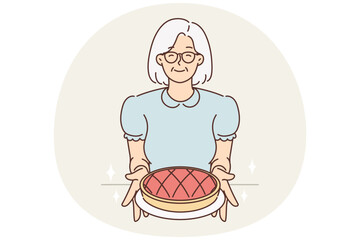 Smiling old grandmother hold homemade pie