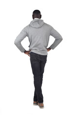back view of a man standing with arms akimbo and legs crossed on white background - 785571207