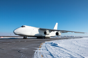 White wide body transport cargo airplane at winter airport