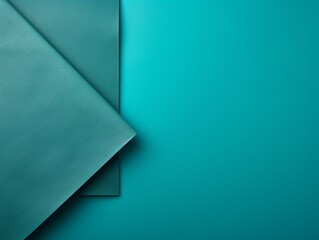 Turquoise background with dark turquoise paper on the right side, minimalistic background, copy space concept, top view, flat lay