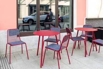 Empty street cafe. Red metal tables and chairs