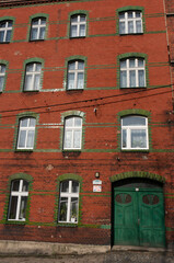 Fototapeta na wymiar Red brick house in Sokola Street (ulica Sokola), door and windows. Bytom, Poland.