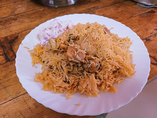 chicken briyani, south indian style dum biriyani.hot and spicy briyani with onion raita on wooden background