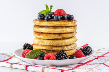 Delicious pancakes with fresh berries on white table. Food concept.