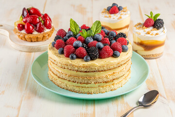 Homemade cake with fresh berries on wooden background.