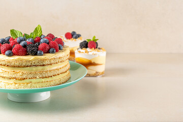 Homemade cake with fresh berries and sweet desserts on table.