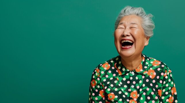 Joyful Senior Woman Laughing Heartily on Green Background