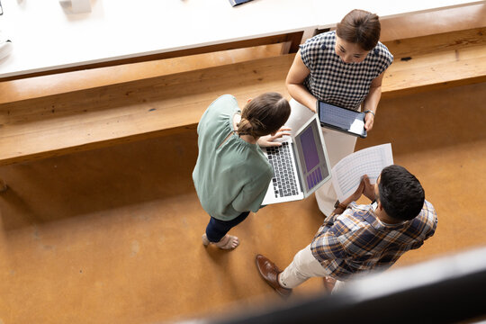 A diverse team of professionals are discussing work in a modern business office