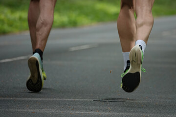 Motion blur of two runners muscular legs and sport shoes