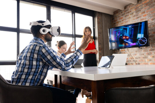 Asian male and Caucasian female colleagues are using virtual reality in a modern business office