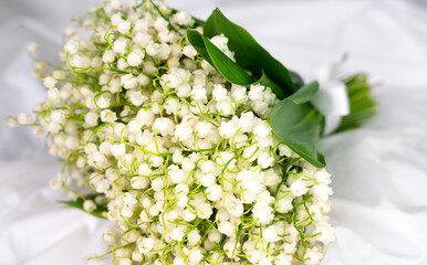 Bouquet beautiful white lilies of the valley on a white background. Greeting card. Selective focus.