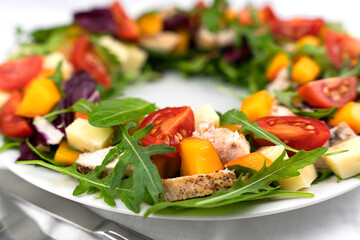 A tasty and healthy salad of chicken, vegetables and fruits on the table. Close-up. Selective focus.