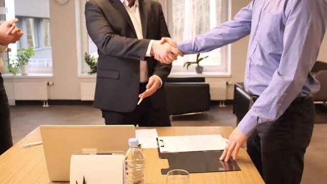 Businessmen conclude discussions with a handshake, affirming the deal. Businessmen express satisfaction, agreement evident. Businessmen's mutual consent highlights successful negotiation.