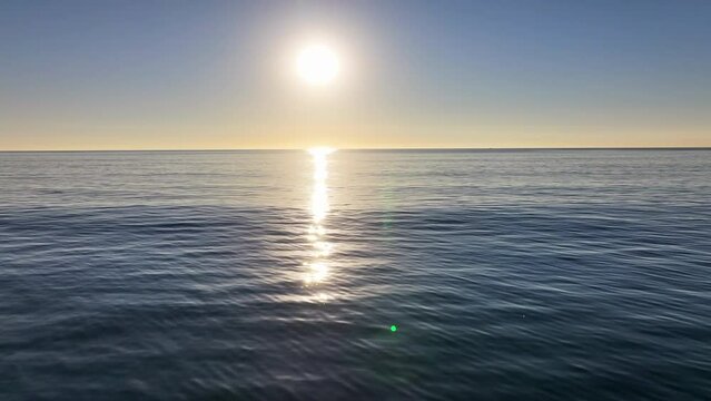 Aerial: The Sun Casts A Gentle Golden Path Across The Calm Expanse Of The Ocean - Manhattan Beach, California