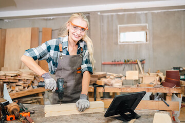 In the carpenter's shop, a professional woman crafts wooden furniture, using tools with skill in her woodwork occupation, showcasing industry prowess.