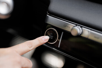 Pressing Stand By Power Button To Turn On and Off the Electric Car Close-Up. Push start stop button...